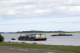 Two barges on the Moose River at Moosonee, Ontario. One carrying equipment and gravel, the other carrying accommodation trailers and vehicles.